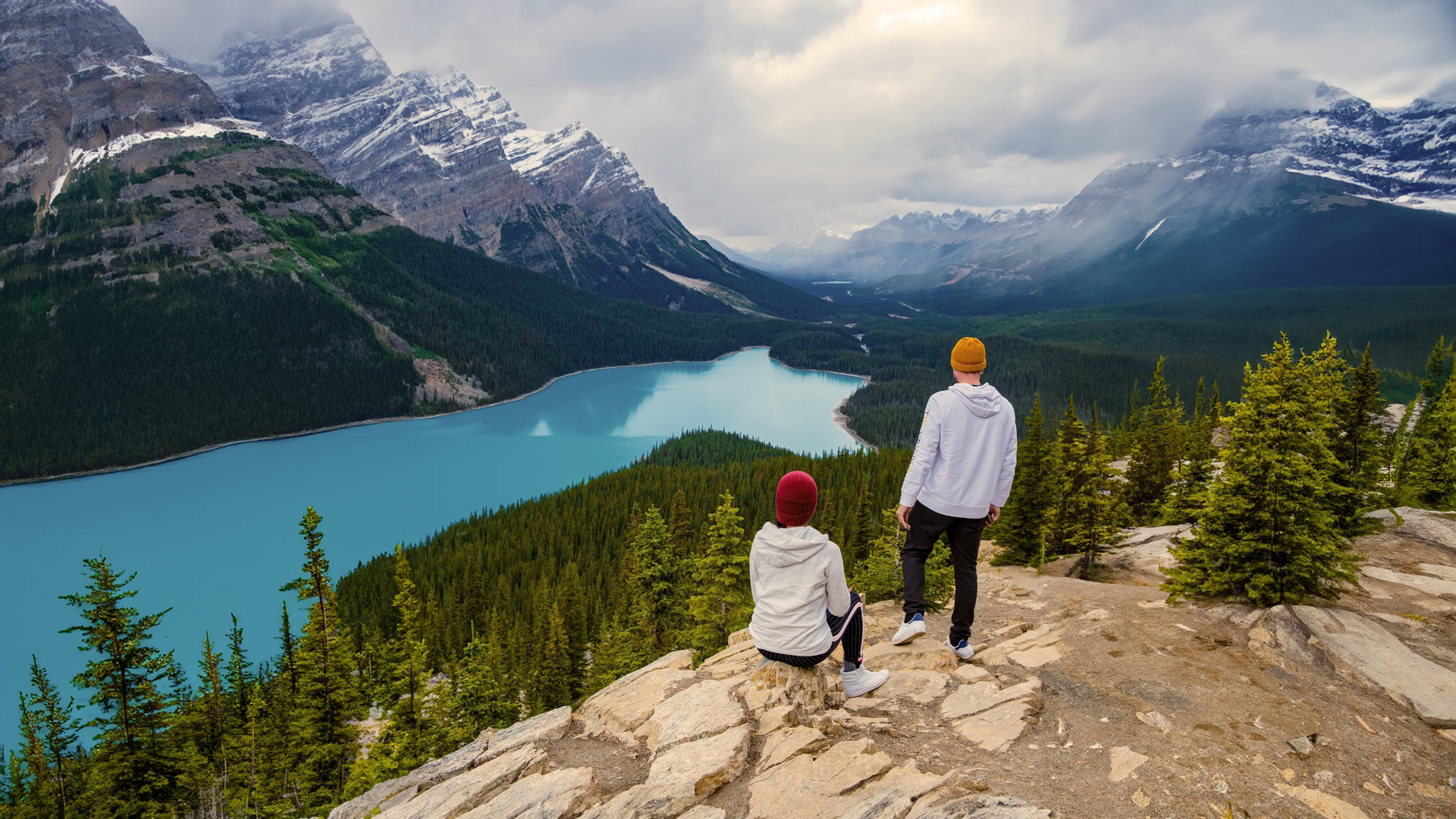 Two hikers overlooking a lake in a national park in Canada.